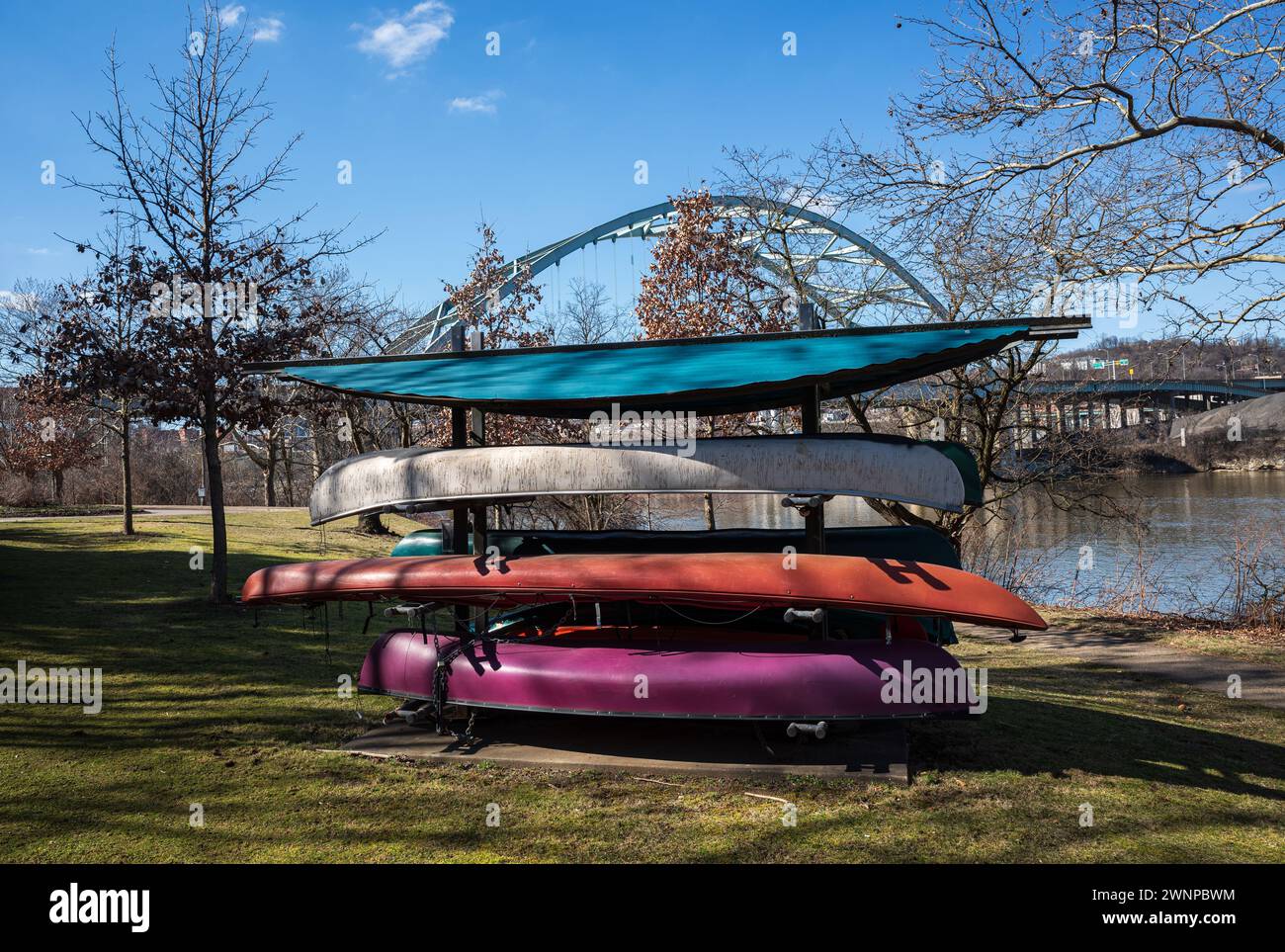 Par une journée de printemps éclatante, des canoës vibrants parsèment la rivière Allegheny sous l'emblématique pont de Birmingham, avec un ciel bleu clair en toile de fond Banque D'Images