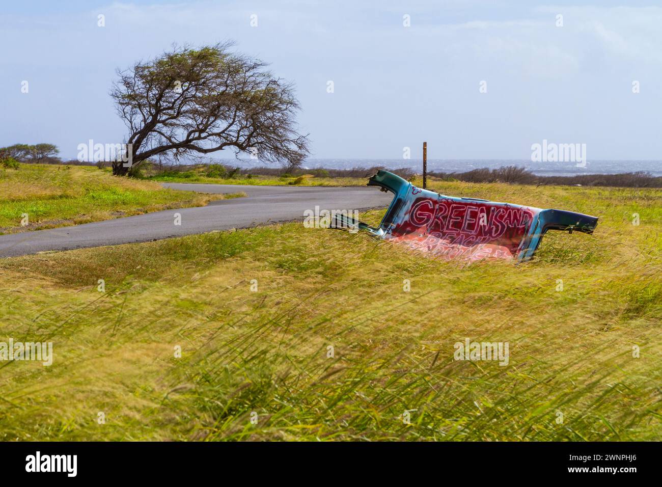 Un panneau pour la plage de sable vert à South point (Ka Lae), Big Island Hawaii, peint sur une pièce de voiture dans un champ au point le plus au sud des États-Unis Banque D'Images