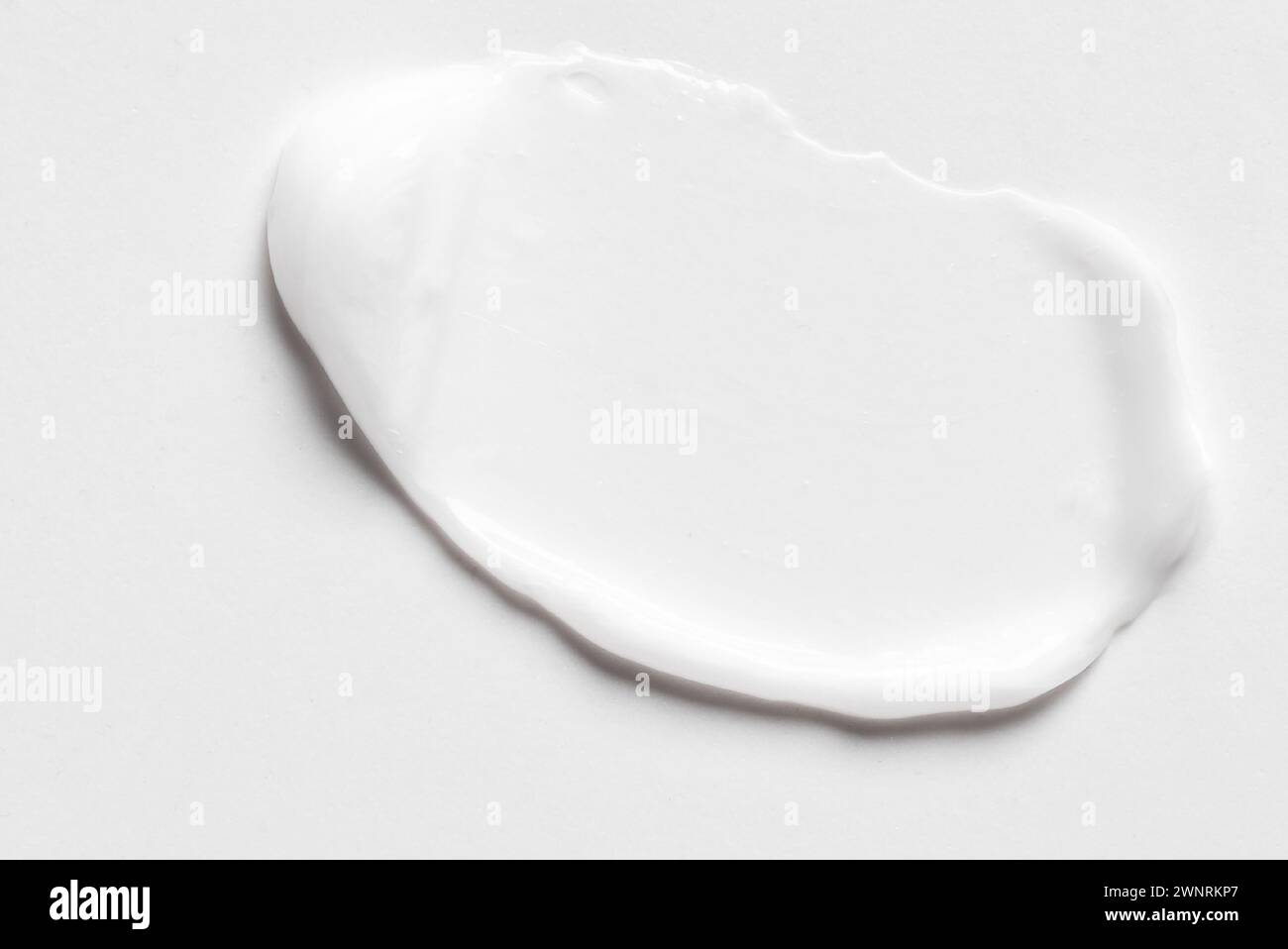 Maculage de smear de lotion cosmétique blanche sur fond blanc. Produit cosmétique en gel léger. Banque D'Images