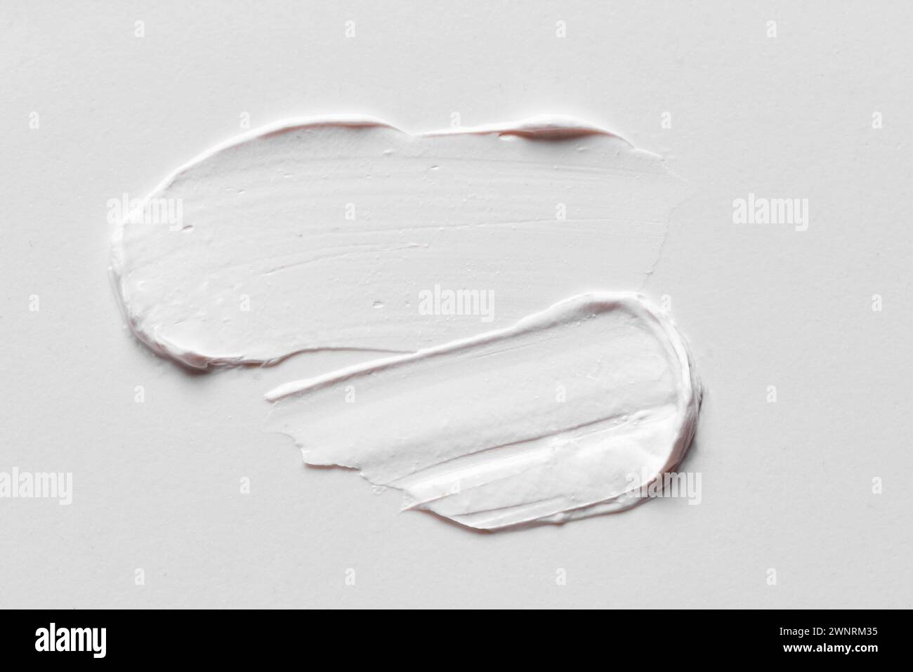 Blanc crème cosmétique Smear Smear taches sur fond blanc gros plan. Coup de produit cosmétique riche. Banque D'Images