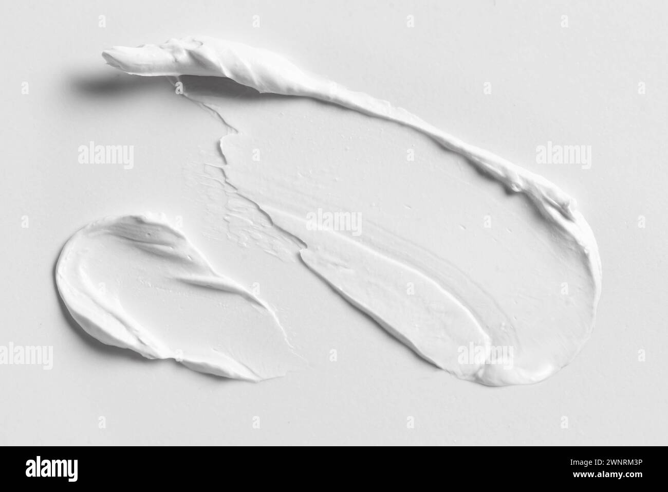 Blanc crème cosmétique Smear Smear taches sur fond blanc gros plan. Coup de produit cosmétique riche. Banque D'Images