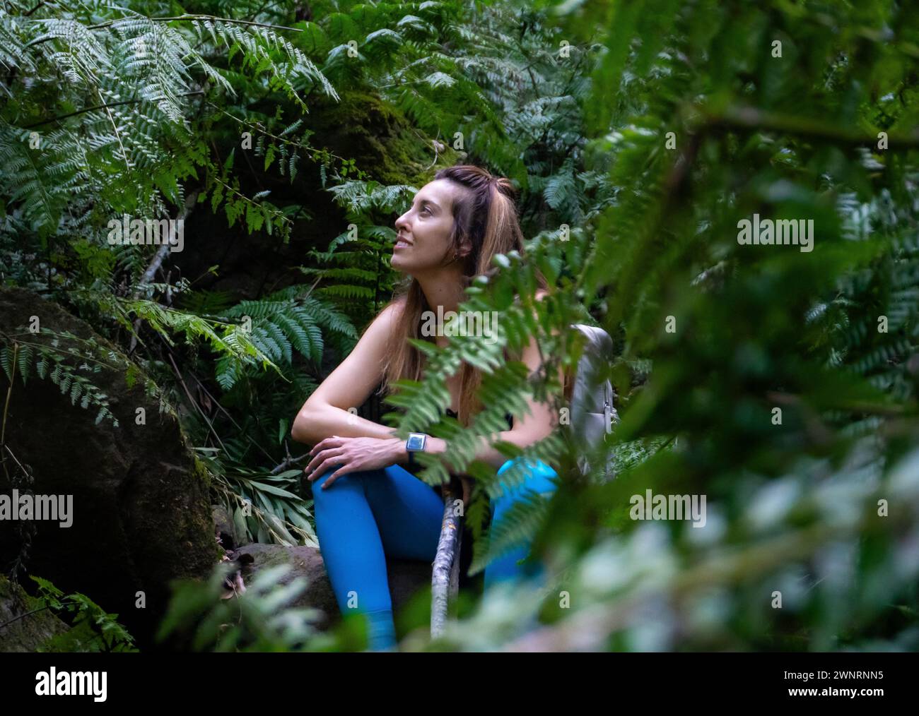 Femme Backpacker et randonneur vêtu de bleu assis dans la jungle en observant la nature à la Palma, île des Canaries Banque D'Images