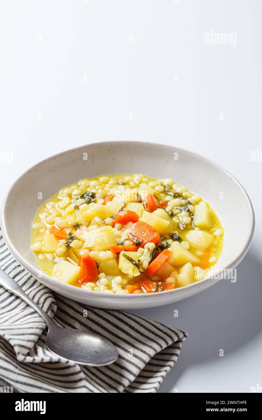 Soupe israélienne traditionnelle avec ptitim, légumes et épinards. Banque D'Images