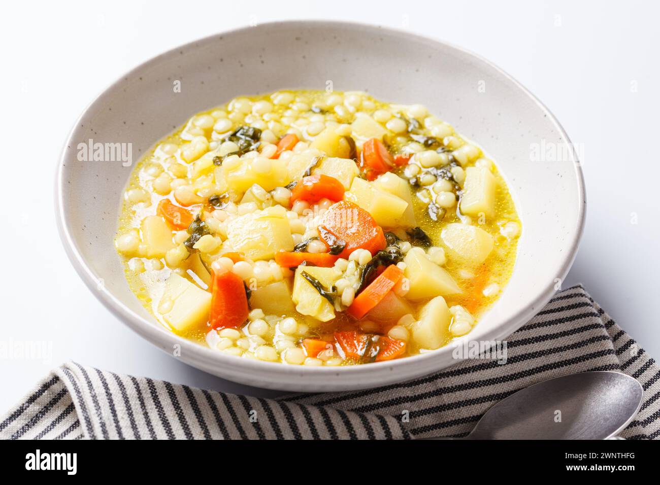 Soupe israélienne traditionnelle avec ptitim, légumes et épinards. Banque D'Images