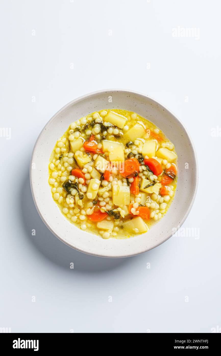 Soupe israélienne traditionnelle avec ptitim, légumes et épinards, vue de dessus. Banque D'Images