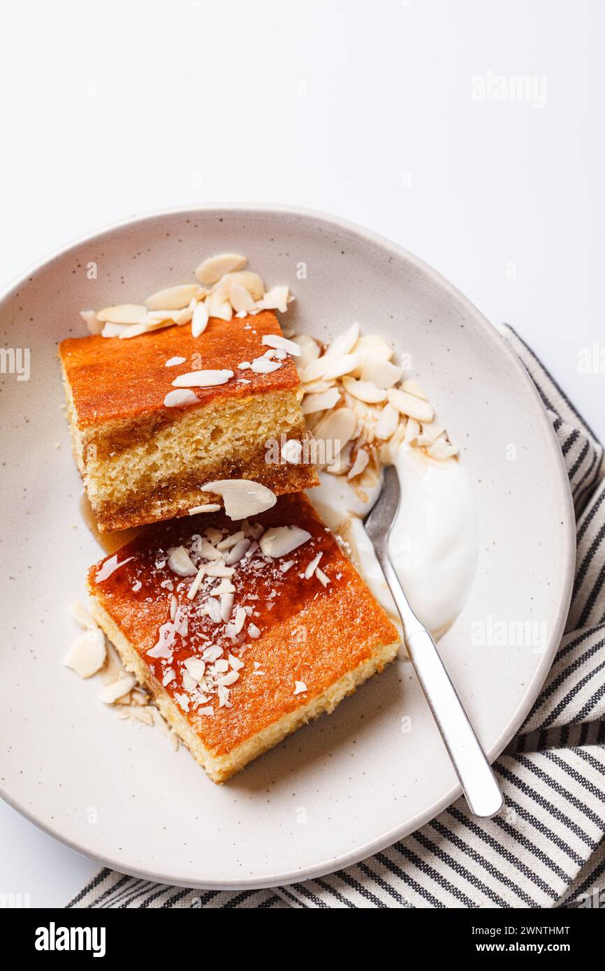 Gâteau israélien aux agrumes. Gâteau à la livre d'orange avec yaourt, amandes et sirop, fond blanc, gros plan. Banque D'Images