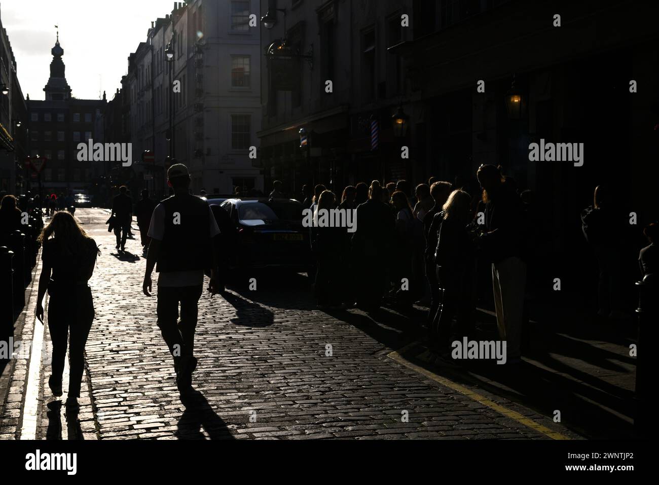 Silhouetted à l'extérieur du Coach and Horses Pub sont des piétons et des buveurs dans le soleil de l'après-midi. Romilly Street, Soho, Londres, Royaume-Uni. 29 septembre 2023 Banque D'Images