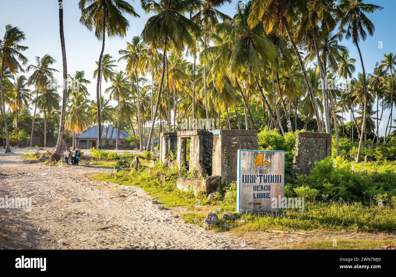 Une maison en ruines, des palmiers et un panneau pour un Lodge de plage dans le village de Jambiani, Zanzibar, Tanzanie. Banque D'Images