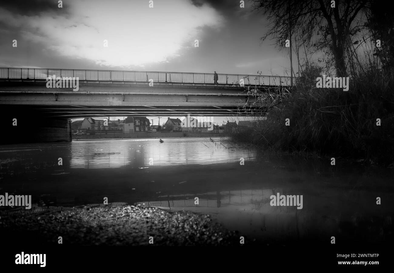 Pont sur la rivière inondée. Personne seule sur le pont. photo noir et blanc. Banque D'Images