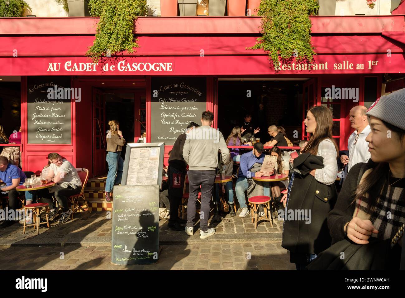 Paris, France - 17 février 2024 : vue de personnes assises à l'extérieur et dégustant un dîner et un verre dans un restaurant bistrot à Montmartre Paris France Banque D'Images