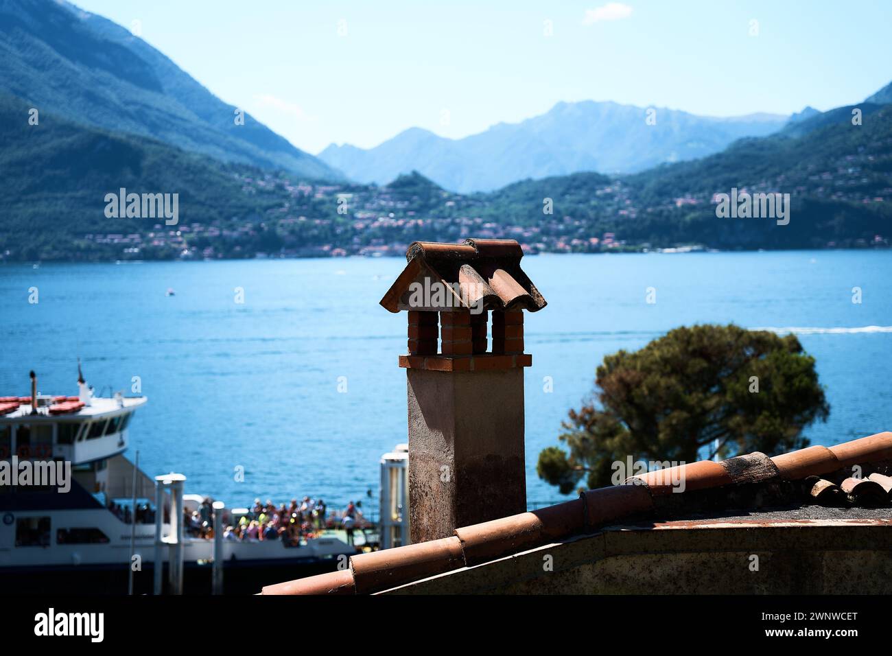 Cheminée sur le toit au premier plan d'un ferry sur le lac de Côme Banque D'Images Cheminée sur le toit au premier plan d'un ferry sur le lac de Côme Banque D'Images