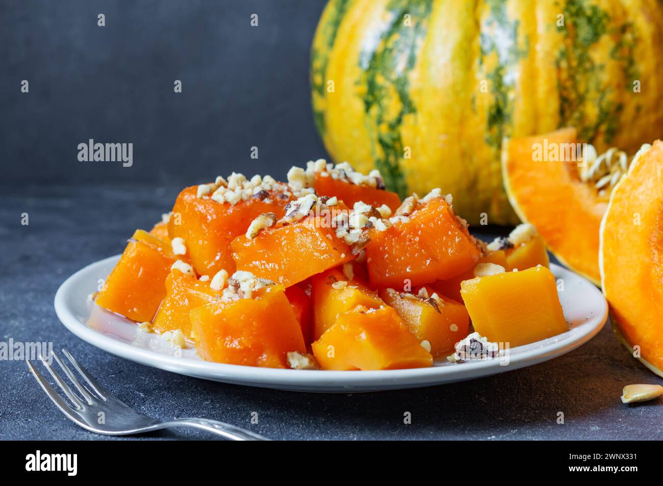 Dessert traditionnel à la citrouille turque avec sorbet sur table rustique et citrouilles fraîches tranchées Banque D'Images