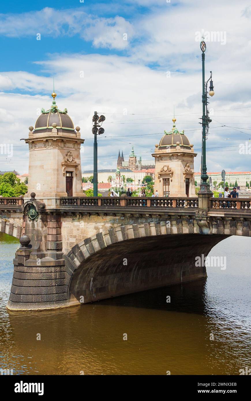 Les gens traversent le magnifique pont de la Légion avec le château de Prague en arrière-plan Banque D'Images