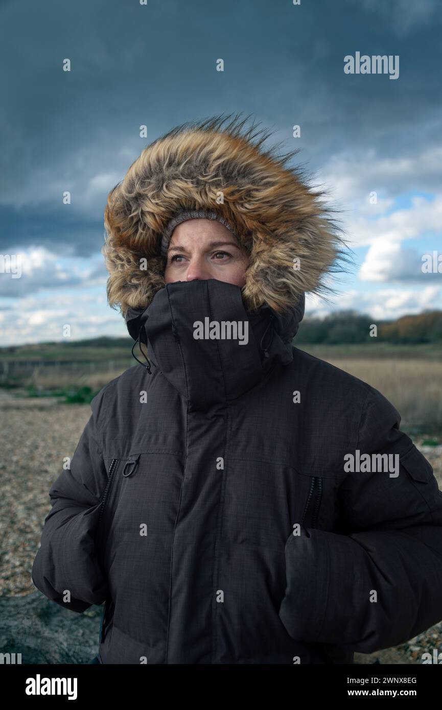 Portrait d'une femme dans un parc bordé de fourrure par mauvais temps Banque D'Images