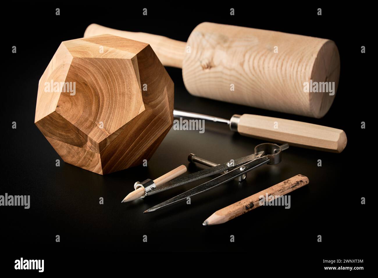 Dodécaèdre en bois fait à la main avec des outils sur un fond noir Banque D'Images