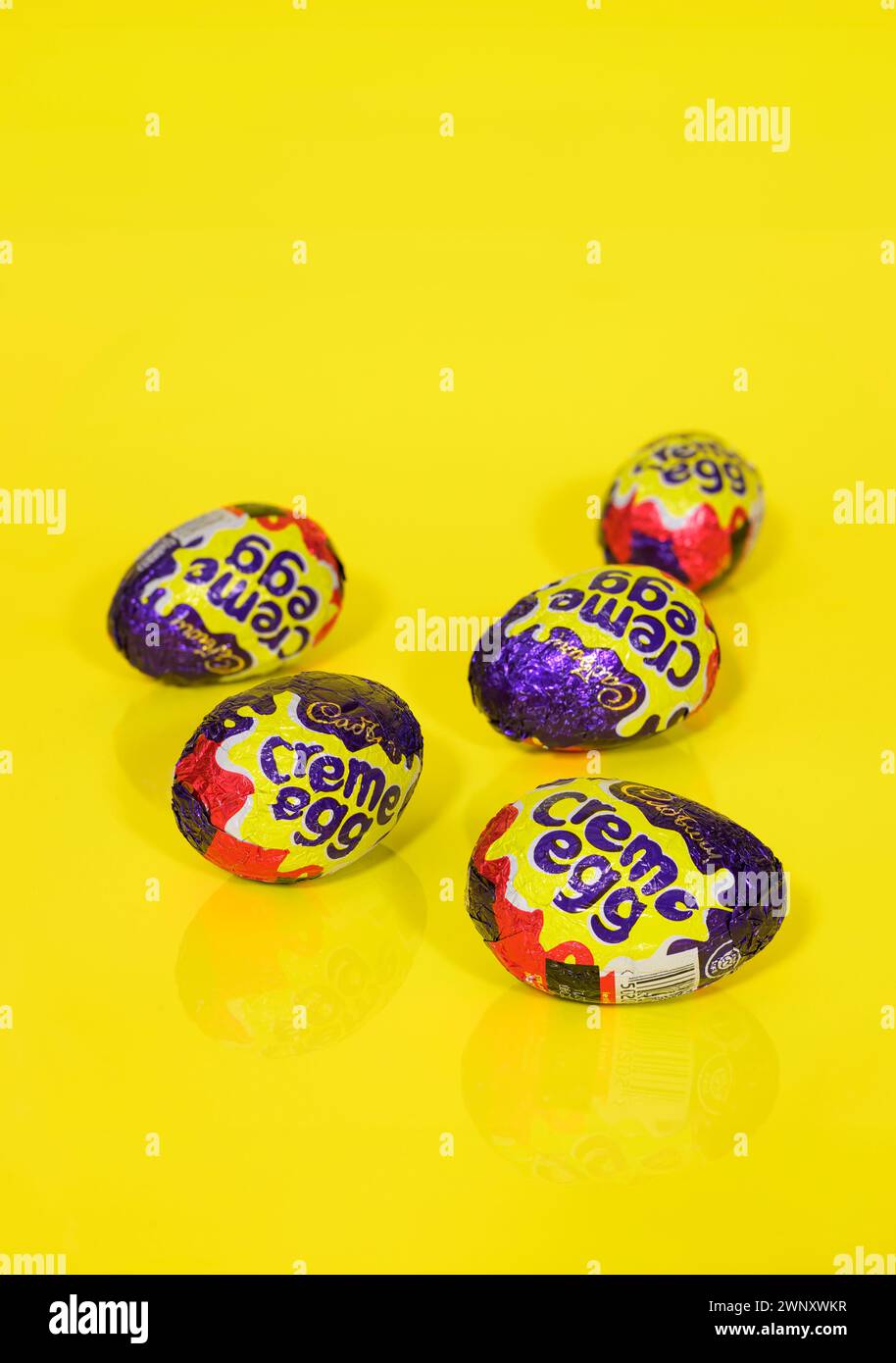 Cinq oeufs Cadbury Creme sur fond jaune, oeufs de Pâques Banque D'Images