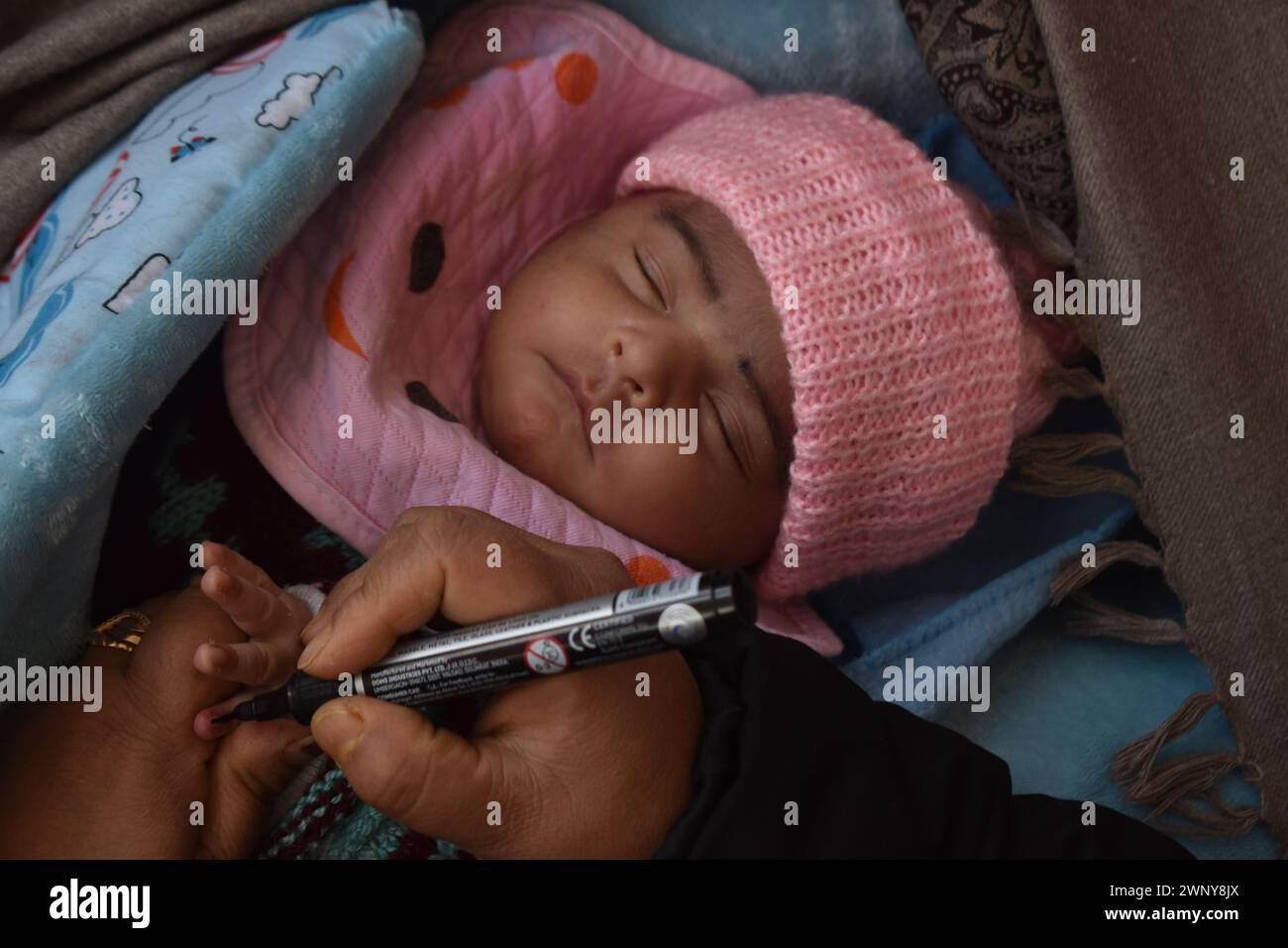 Srinagar, Inde. 03 mars 2024. 3 mars 2024, Srinagar, Inde : un travailleur de la santé marque la main d'un bébé avec un marqueur après avoir administré un vaccin oral contre la polio dans le cadre de la campagne nationale de vaccination contre la polio dans le but de vacciner la plupart des enfants contre la polio dans un centre de santé de Srinagar. Le 3 mars 2024 à Srinagar, Inde. (Photo par Umer Qadir/ Eyepix Group/SIPA USA) crédit : SIPA USA/Alamy Live News Banque D'Images