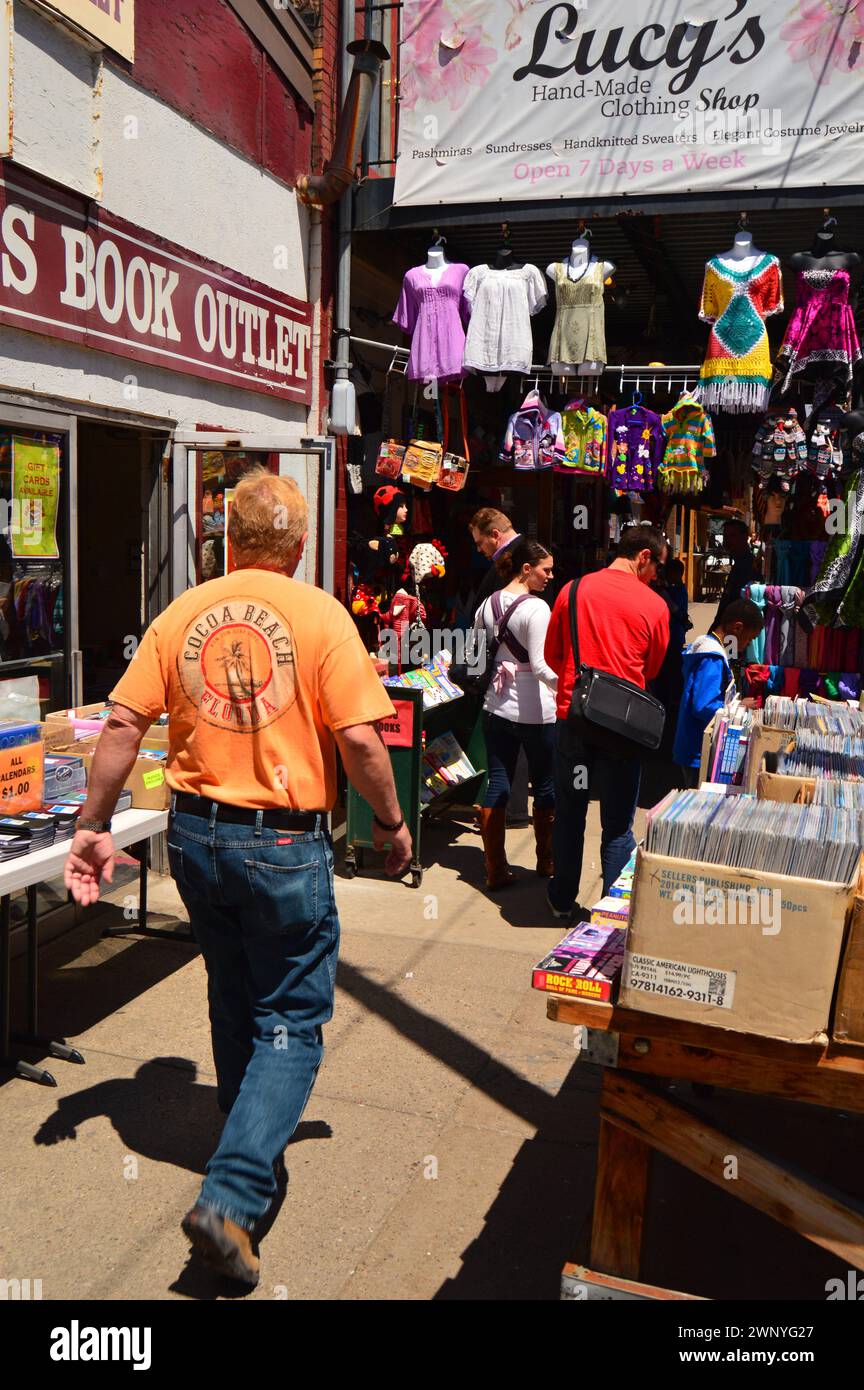 Les amateurs de bonnes affaires recherchent des vêtements et des livres vintage et usagés sur les trottoirs de vente dans le Strip District de Pittsburgh Banque D'Images