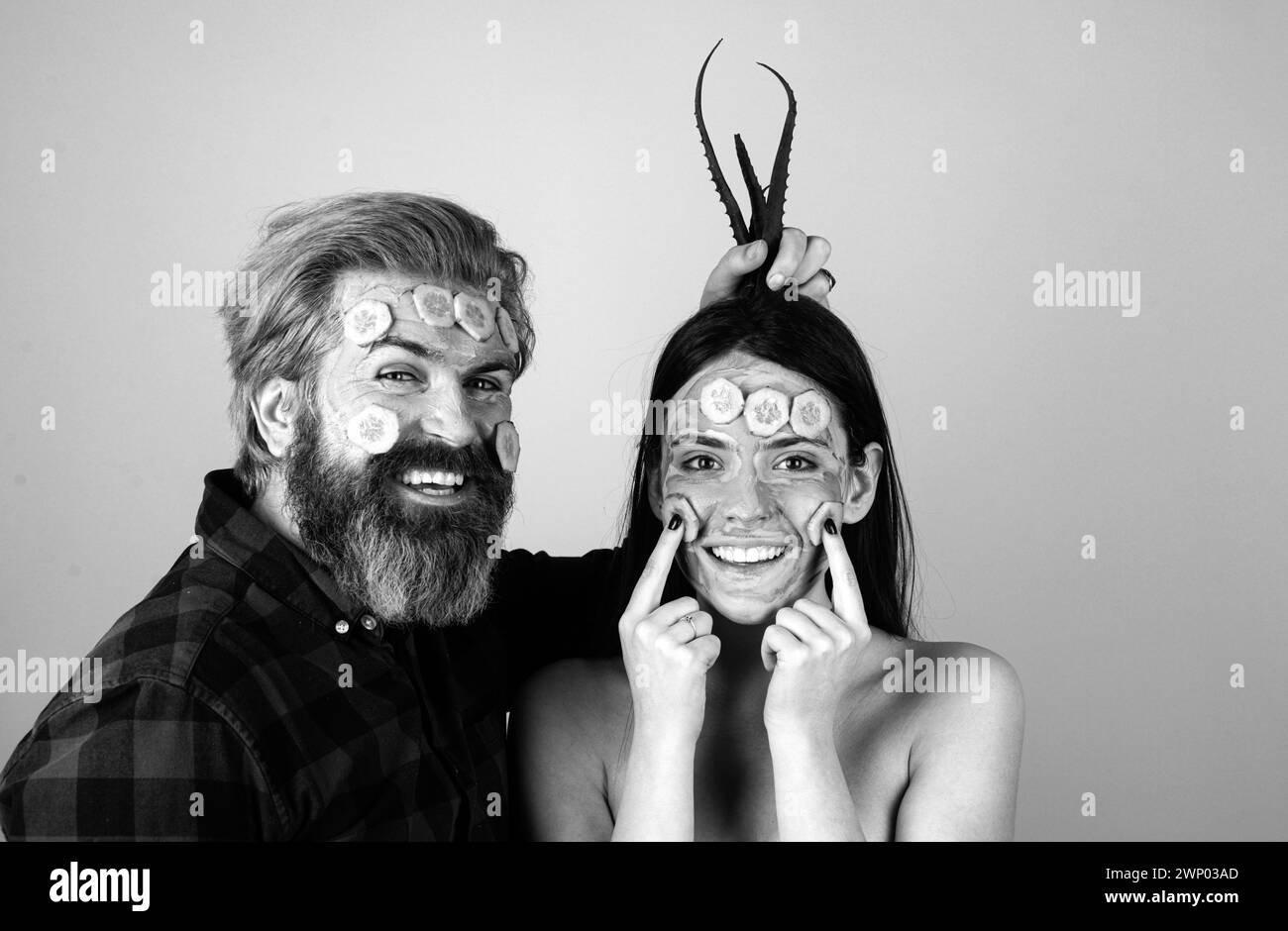 Couple drôle avec masque de concombre sur le visage. Fille avec soin du visage peau fraîche et propre concept de beauté. Banque D'Images