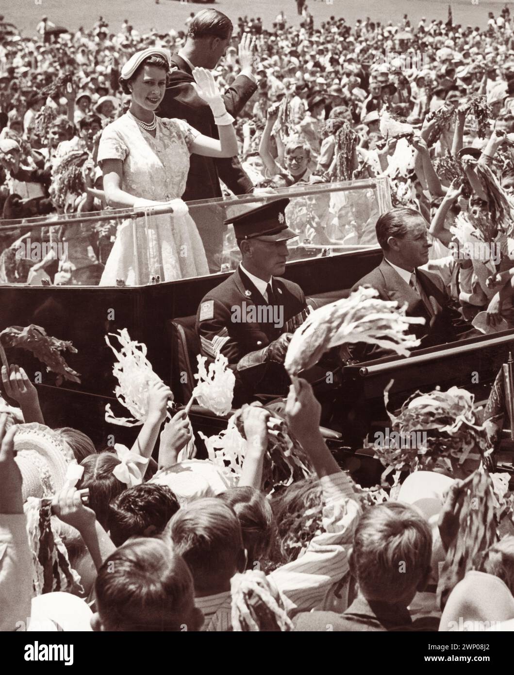 La jeune reine Elizabeth II et le prince Philip, duc d'Édimbourg, faisant signe à la foule lors de leur visite royale à Brisbane, Queensland, Australie en 1954. Banque D'Images