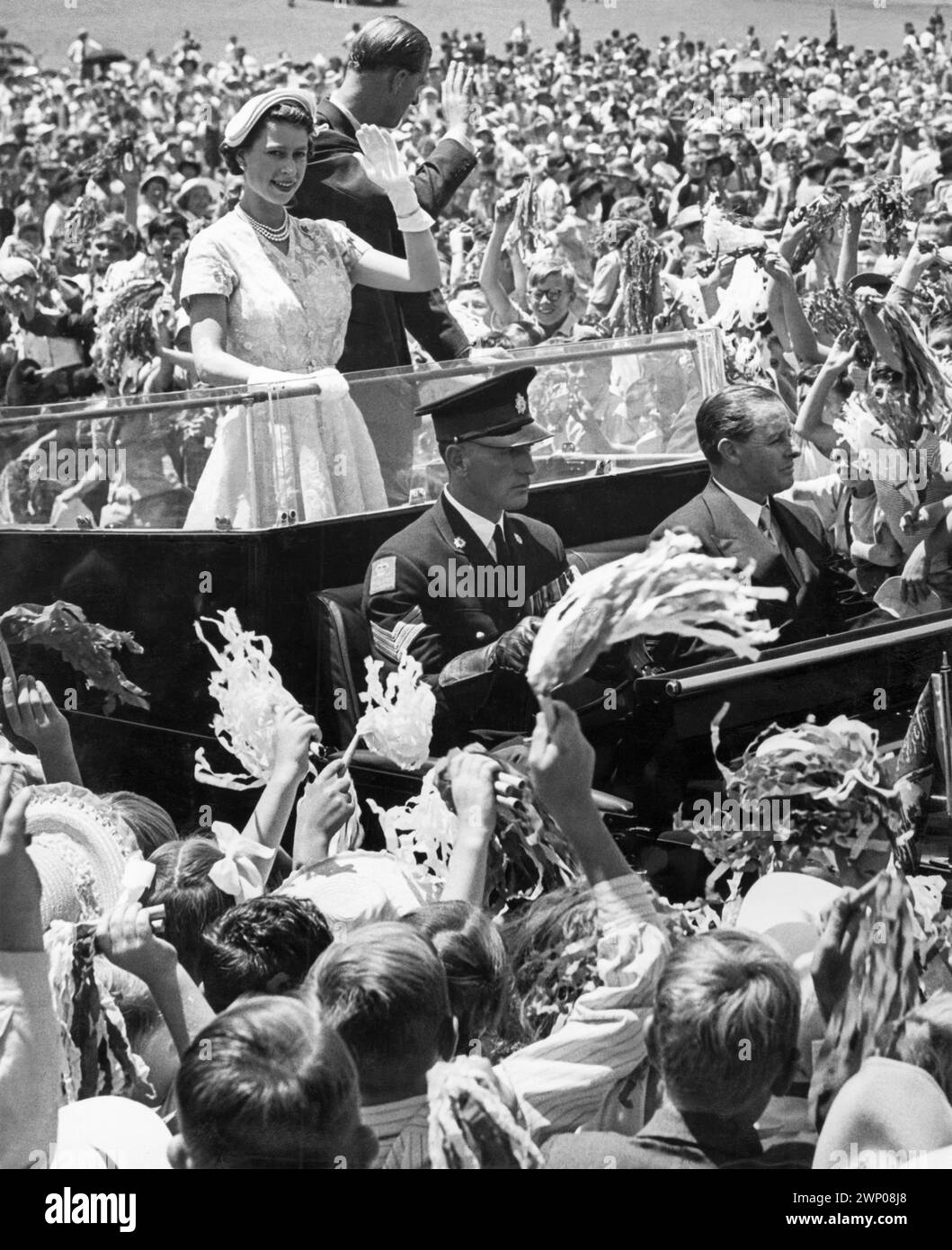 La jeune reine Elizabeth II et le prince Philip, duc d'Édimbourg, faisant signe à la foule lors de leur visite royale à Brisbane, Queensland, Australie en 1954. Banque D'Images