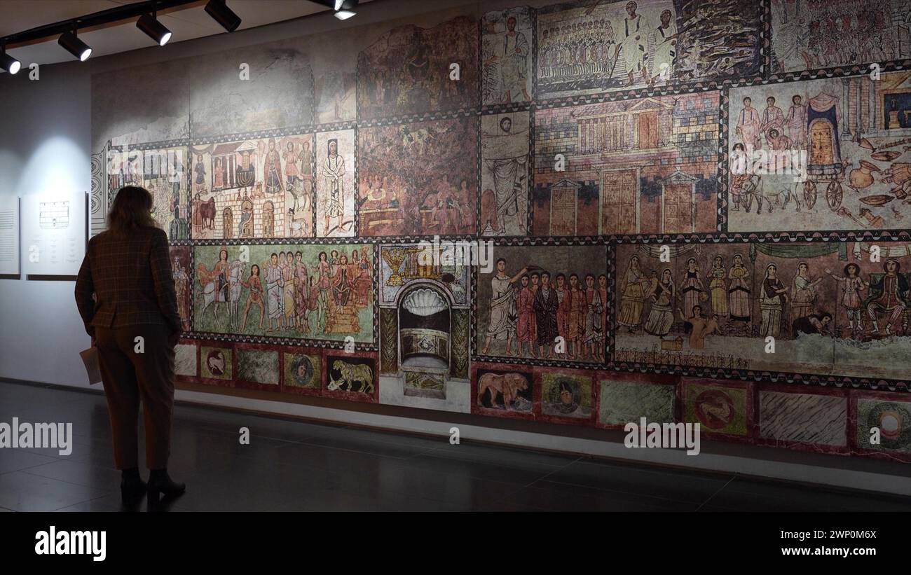 Un visiteur regarde une peinture murale reconstruite de la synagogue Dura-Europos découverte en 1932 en Syrie, exposée au Musée du peuple juif de l’ANU situé au centre du campus de l’Université de tel Aviv le 4 mars 2024 à tel Aviv, en Israël. Le Musée offre un récit diversifié de la culture, de la foi et des actes juifs, vus du point de vue de l'histoire juive et de la vie contemporaine. Banque D'Images