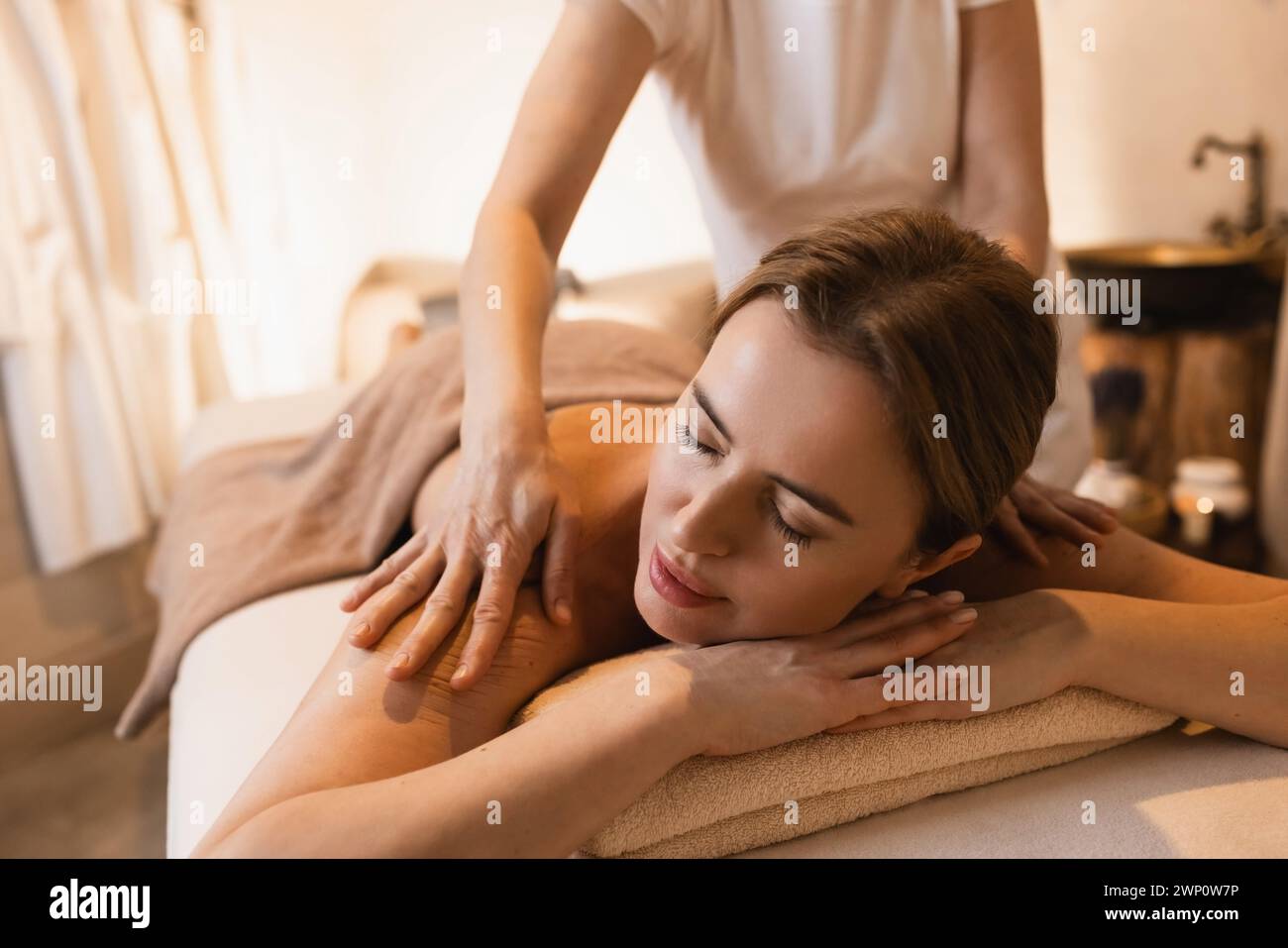Femme heureuse appréciant le massage du dos pendant le week-end de temps sur la station thermale. Belle femme se détend pendant le massage du dos Banque D'Images