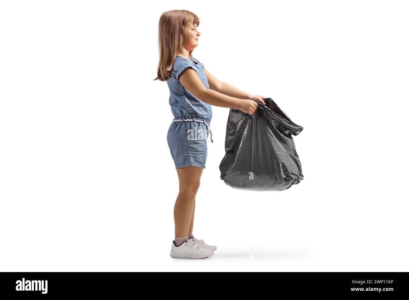 Petite fille tenant un sac à déchets en plastique noir ouvert isolé sur fond blanc Banque D'Images