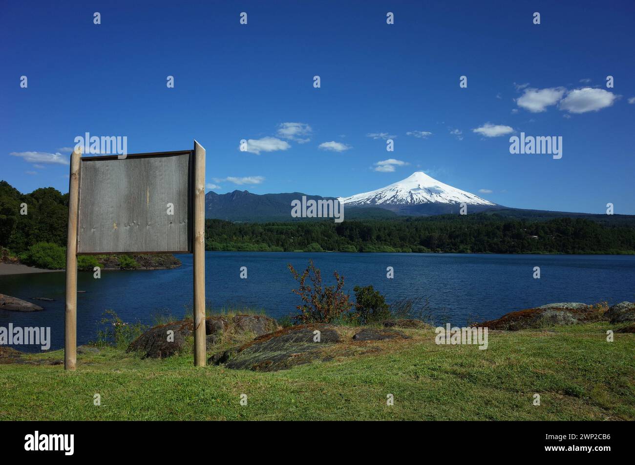 Panneau d'information en bois vierge avec vue sur le volcan Villarrica enneigé et le lac Villarrica. Nature du Chili. Pucon Banque D'Images