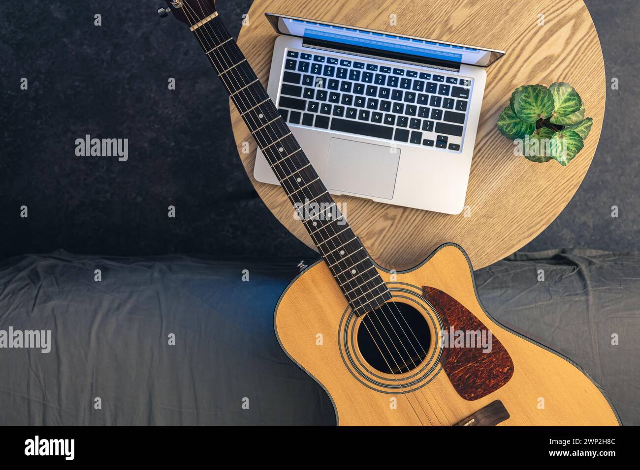 Guitare acoustique et ordinateur portable sur une table en bois, vue de dessus. Banque D'Images