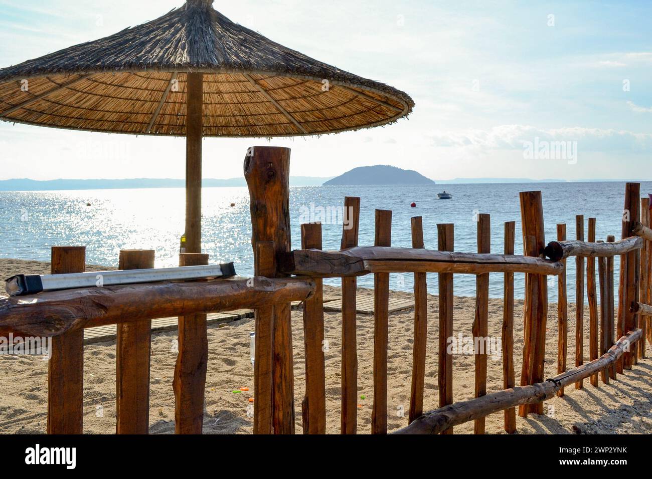 Plage de sable, parasol et clôture en bois. Vacances à la mer, Grèce. Banque D'Images