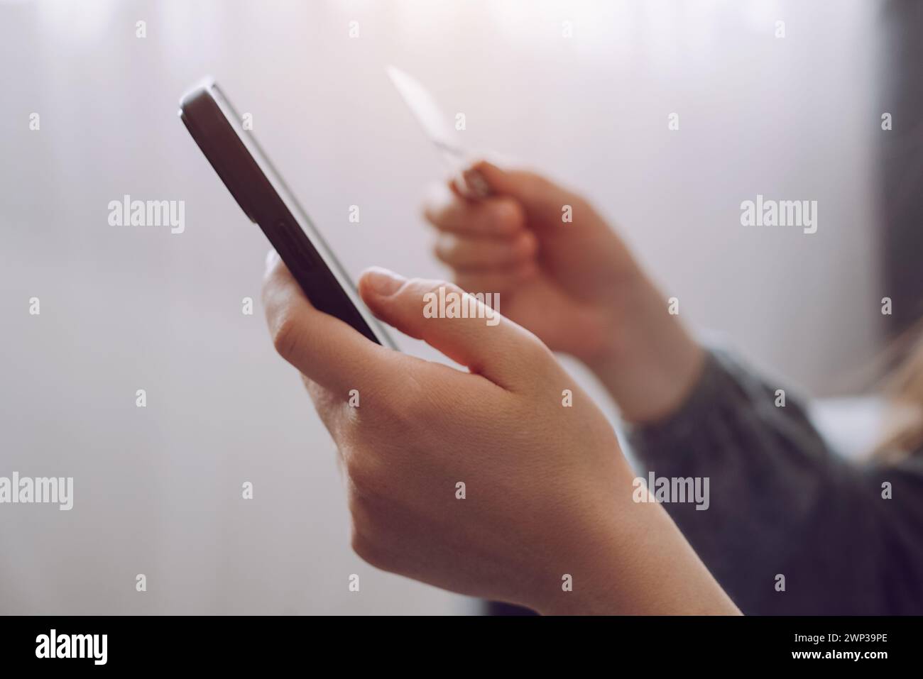 Gros plan des mains féminines tenant la carte de crédit et smartphone, jeune femme payant en ligne, en utilisant le service bancaire, la saisie d'informations, shopping, orderin Banque D'Images