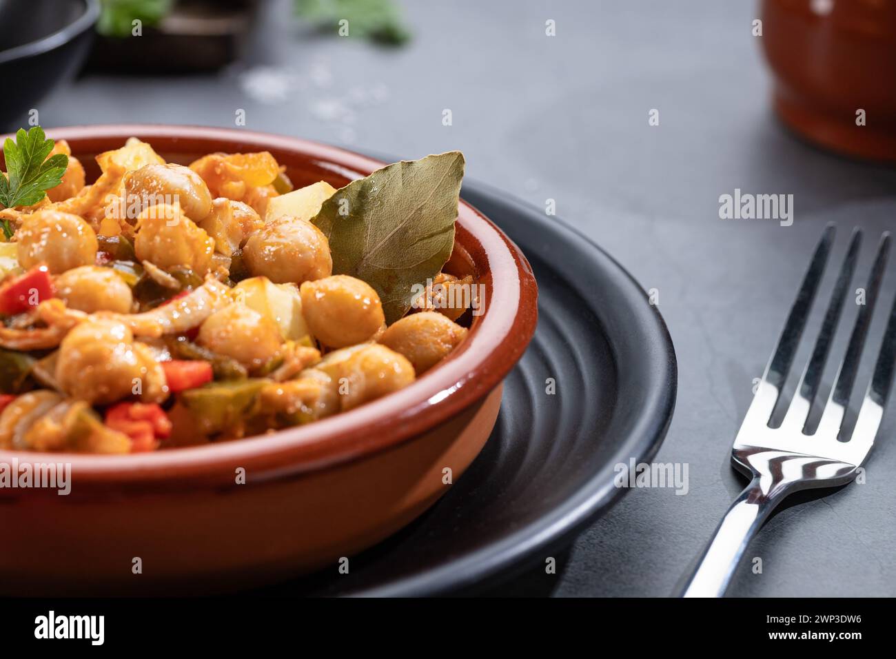 Gros plan. Ropa vieja, plat canarien typique de pois chiches ragoût sur casserole en faïence sur fond sombre. Banque D'Images