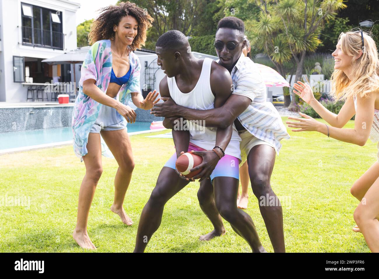 Groupe diversifié d'amis profiter d'un jeu ludique de football en plein air Banque D'Images