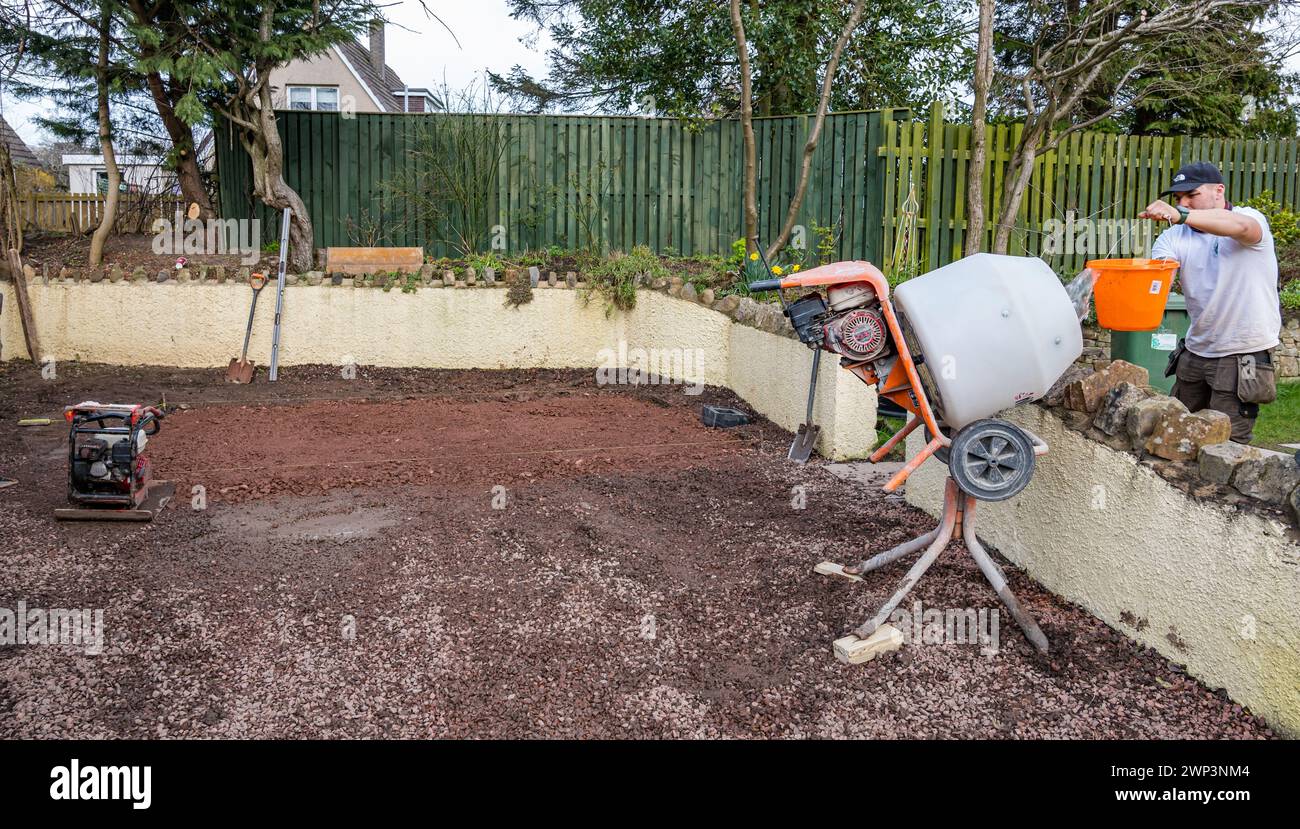 Base de noyau ard prête pour les dalles avec mélangeur de ciment dans une allée pour construire une salle de jardin, Écosse, Royaume-Uni Banque D'Images