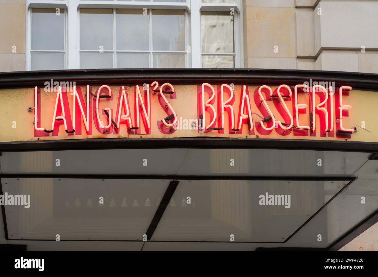 Panneau lumineux au néon au-dessus de l'entrée principale du restaurant Langan's Brasserie sur Stratton Street, Piccadilly, Londres, Angleterre, Royaume-Uni Banque D'Images