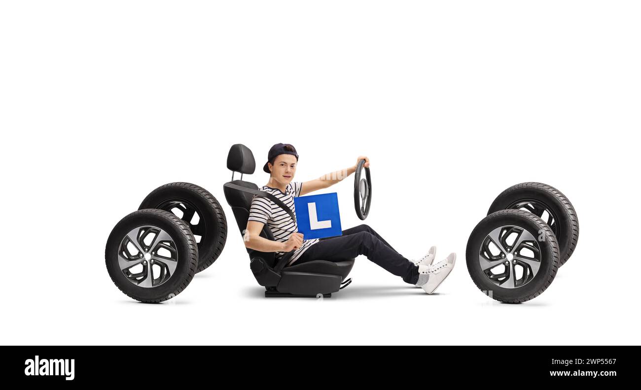 Adolescent conducteur masculin dans un siège d'auto tenant l-plaque isolé sur fond blanc Banque D'Images