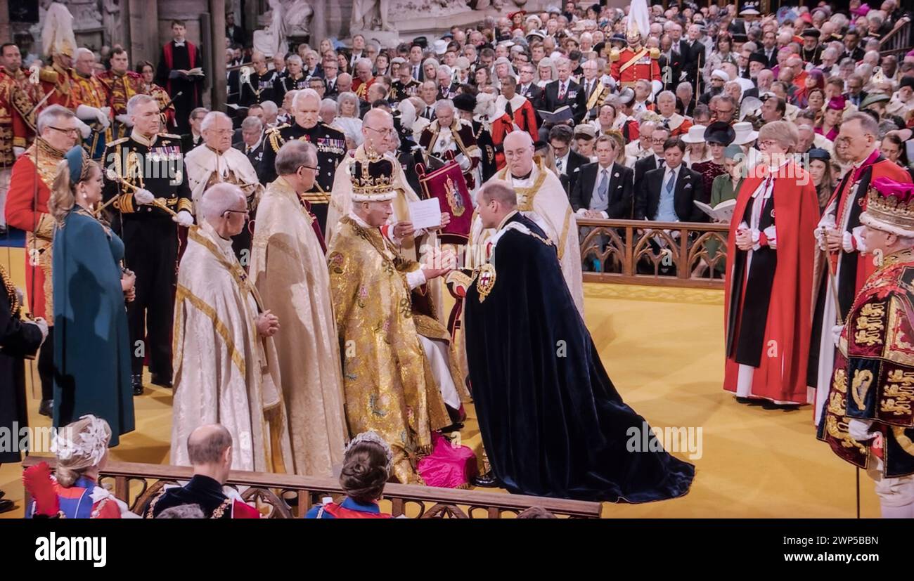 Hommage du roi Charles III couronnement avec le prince William, prince de Galles, duc de Cambridge, s'agenouille devant son père le roi Charles III, et place ses mains entre les mains du roi et dit: 'moi, William, Prince de Galles, je vous promets ma loyauté et la foi et la vérité que je vous porterai, en tant qu'homme de vie et de membre de votre siège. Abbaye de Westminster Westminster Londres Royaume-Uni 6 mai 2023 Banque D'Images