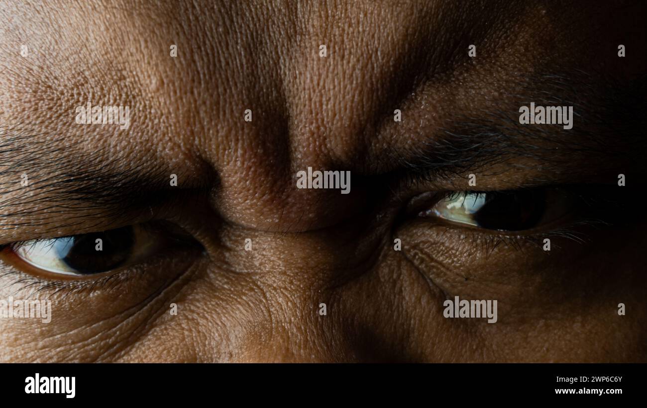 Gros plan des yeux regardant vers l'avant, avec un visage froncé de sourcils et en colère Banque D'Images