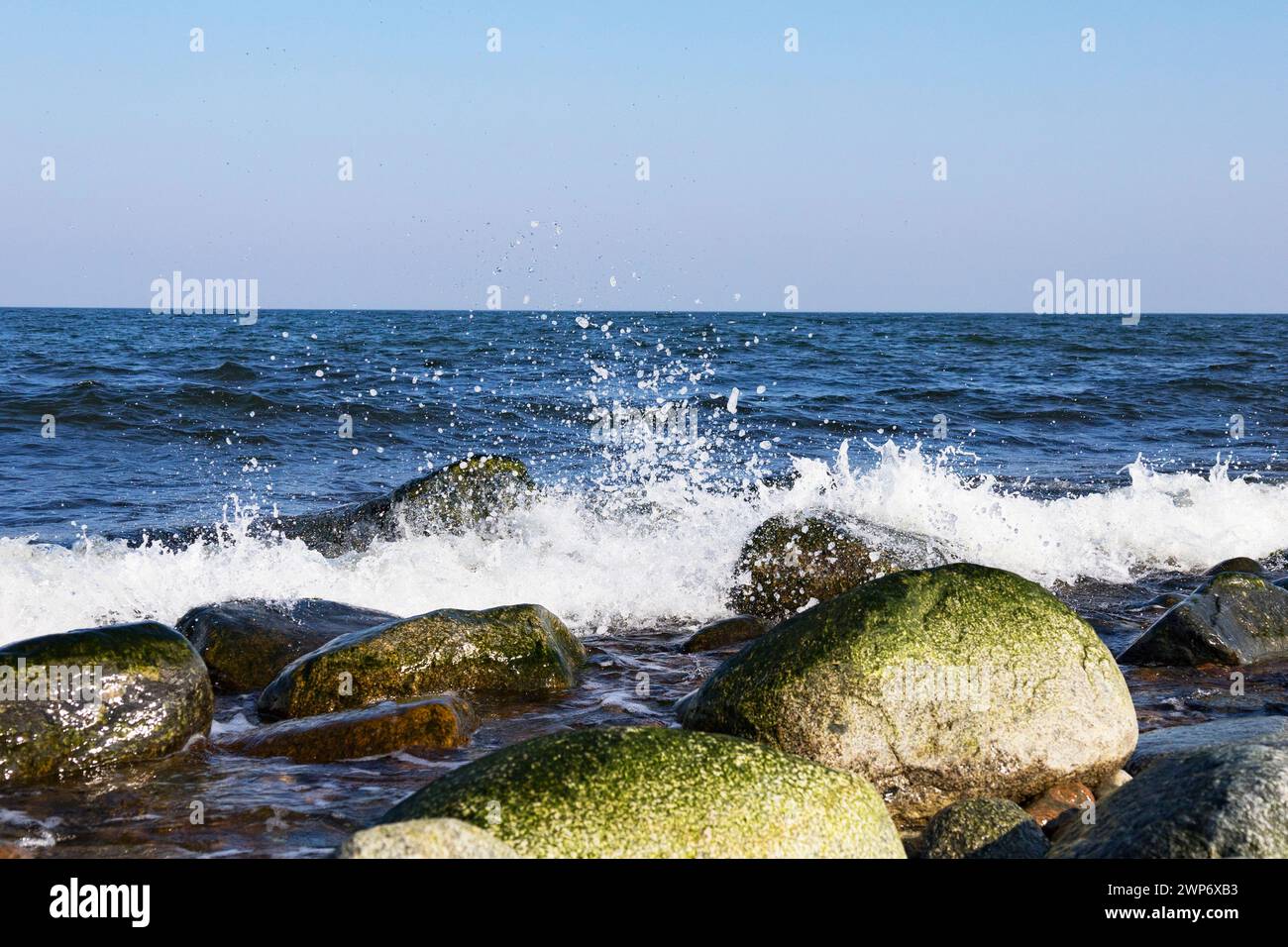La vague de la mer bat contre une pierre sur le rivage. Mer bleue et rivage rocheux. Banque D'Images La vague de la mer bat contre une pierre sur le rivage. Mer bleue et rivage rocheux. Banque D'Images