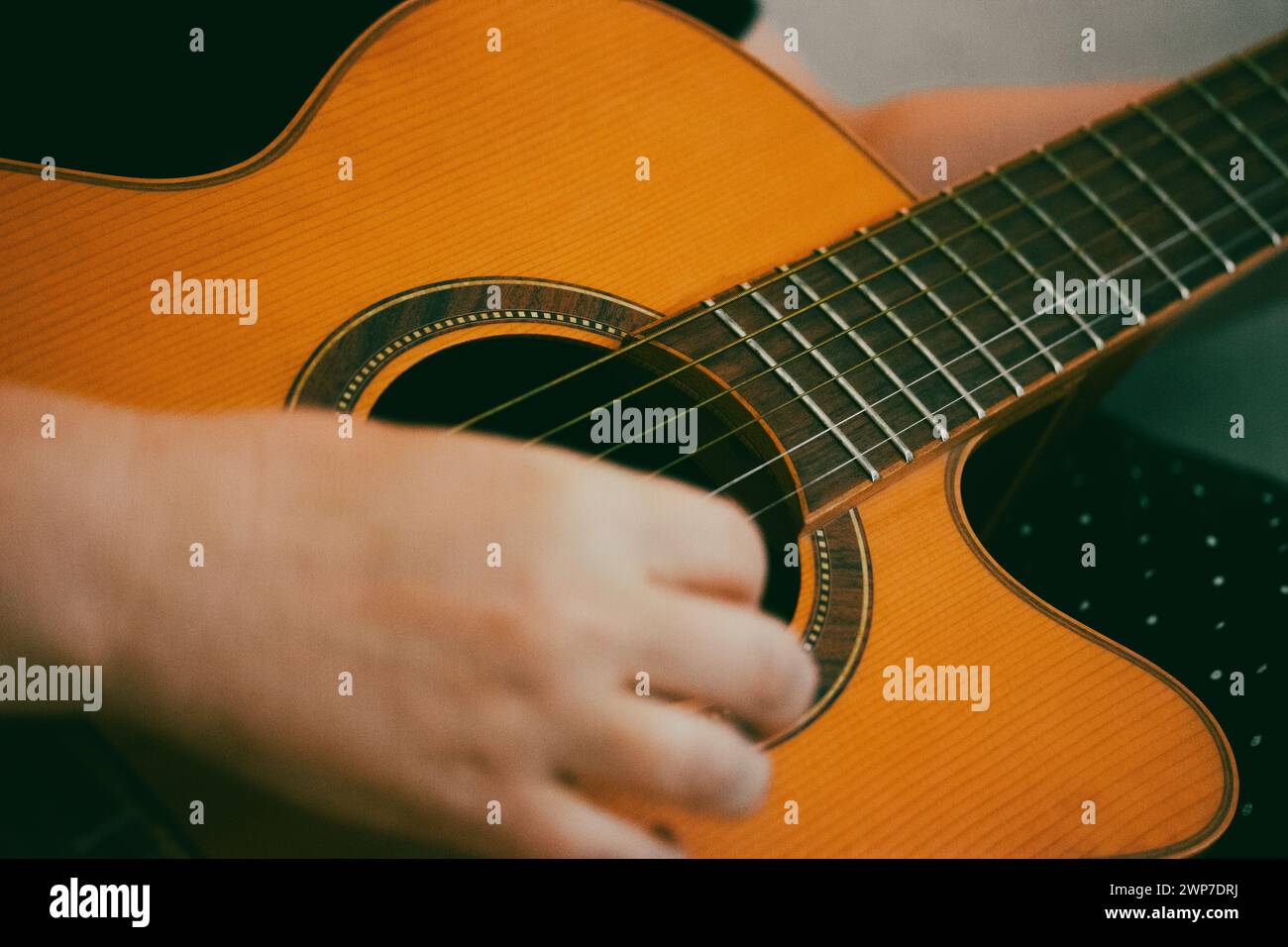 Femme sans visage jouant une vieille guitare acoustique classique. Les mains du guitariste en gros plan. Composer une composition musicale, faire de la musique. Couleurs vintage. Banque D'Images