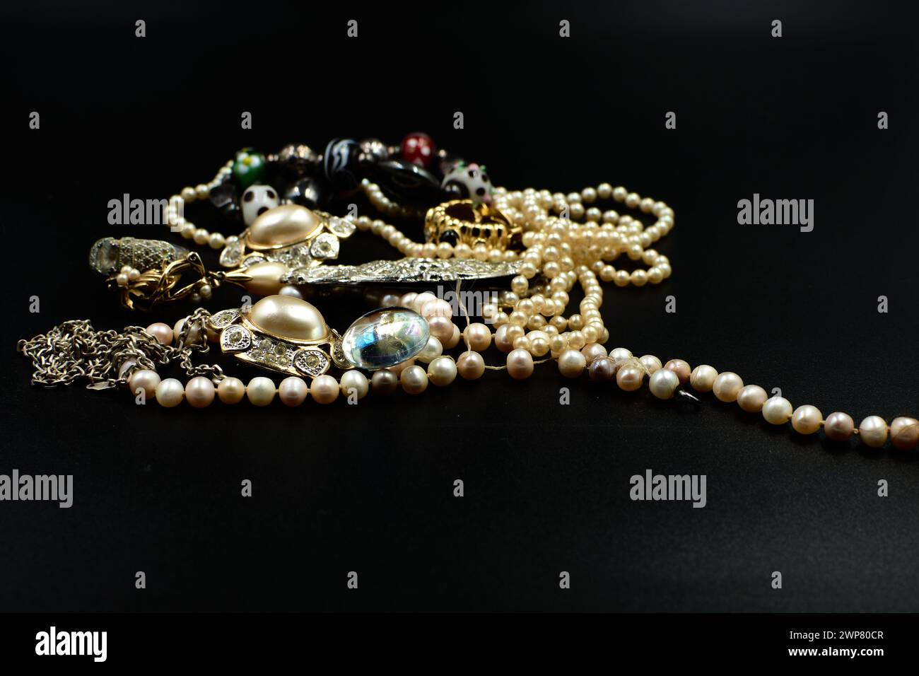 Colliers et bracelets de perles assortis en trois couleurs sur une surface plane Banque D'Images