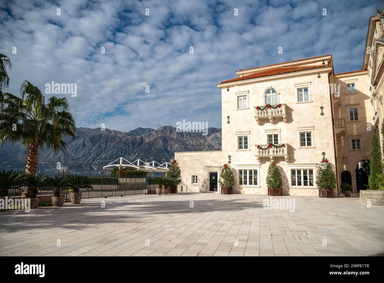 Une cour italienne avec des palmiers et vue sur la montagne Banque D'Images