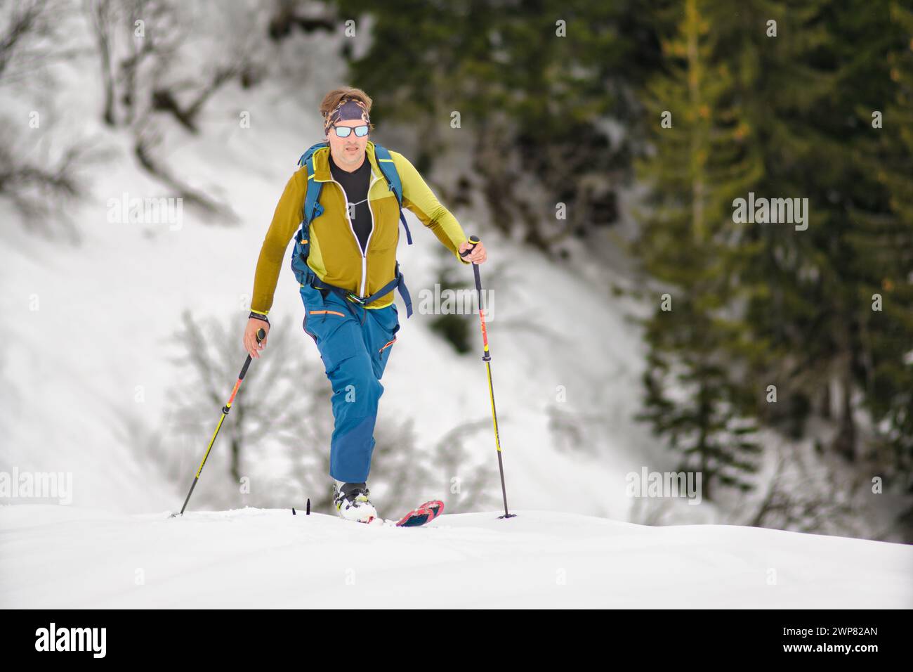 Un skieur sportif grimpe avec des peaux de phoque sur les pré-Alpes italiennes Banque D'Images