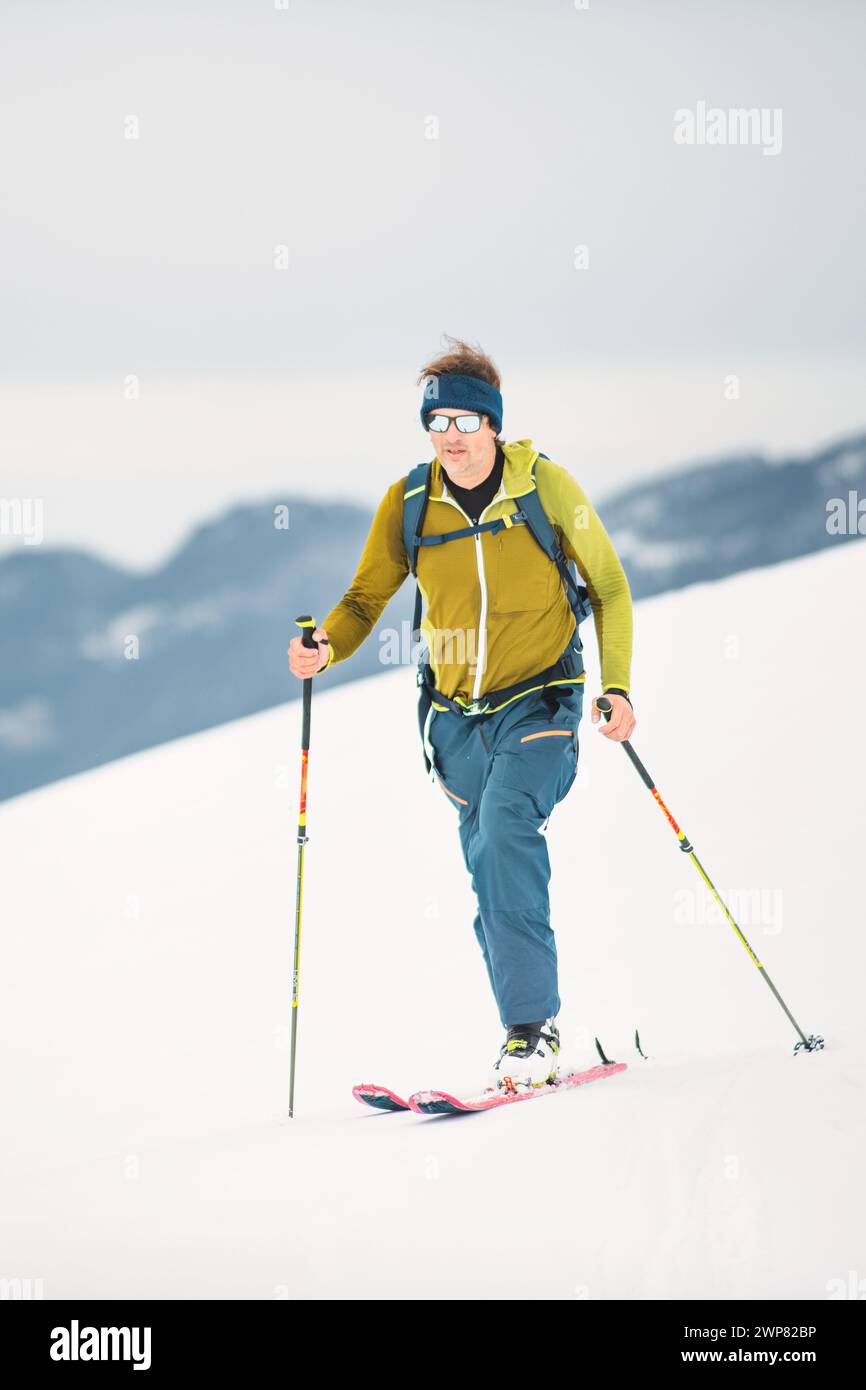 Seul homme monte sur des skis avec des peaux de phoque sur les pré-Alpes italiennes Banque D'Images