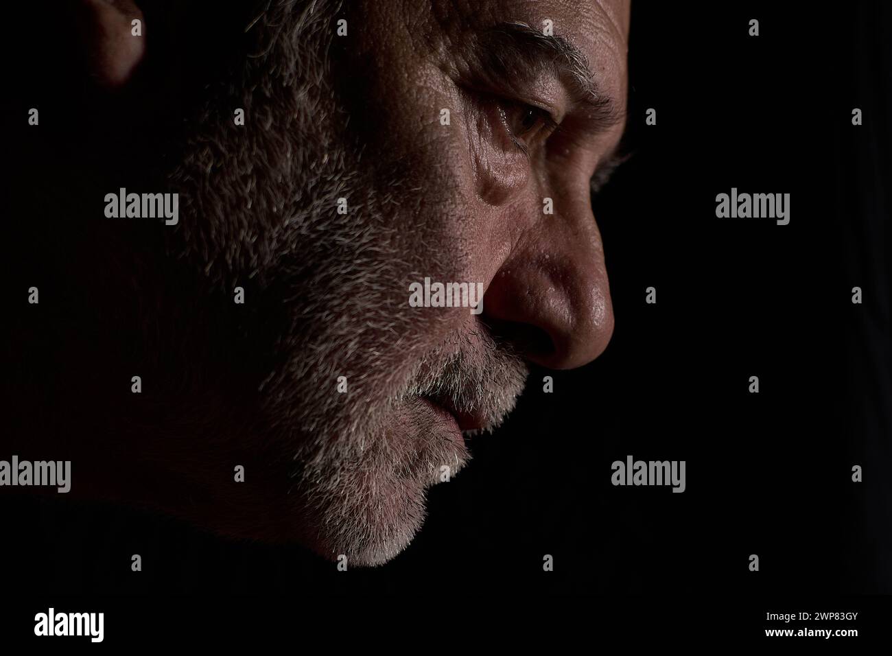 Portrait de profil d'un homme d'âge moyen sur fond noir, généré par IA. Banque D'Images