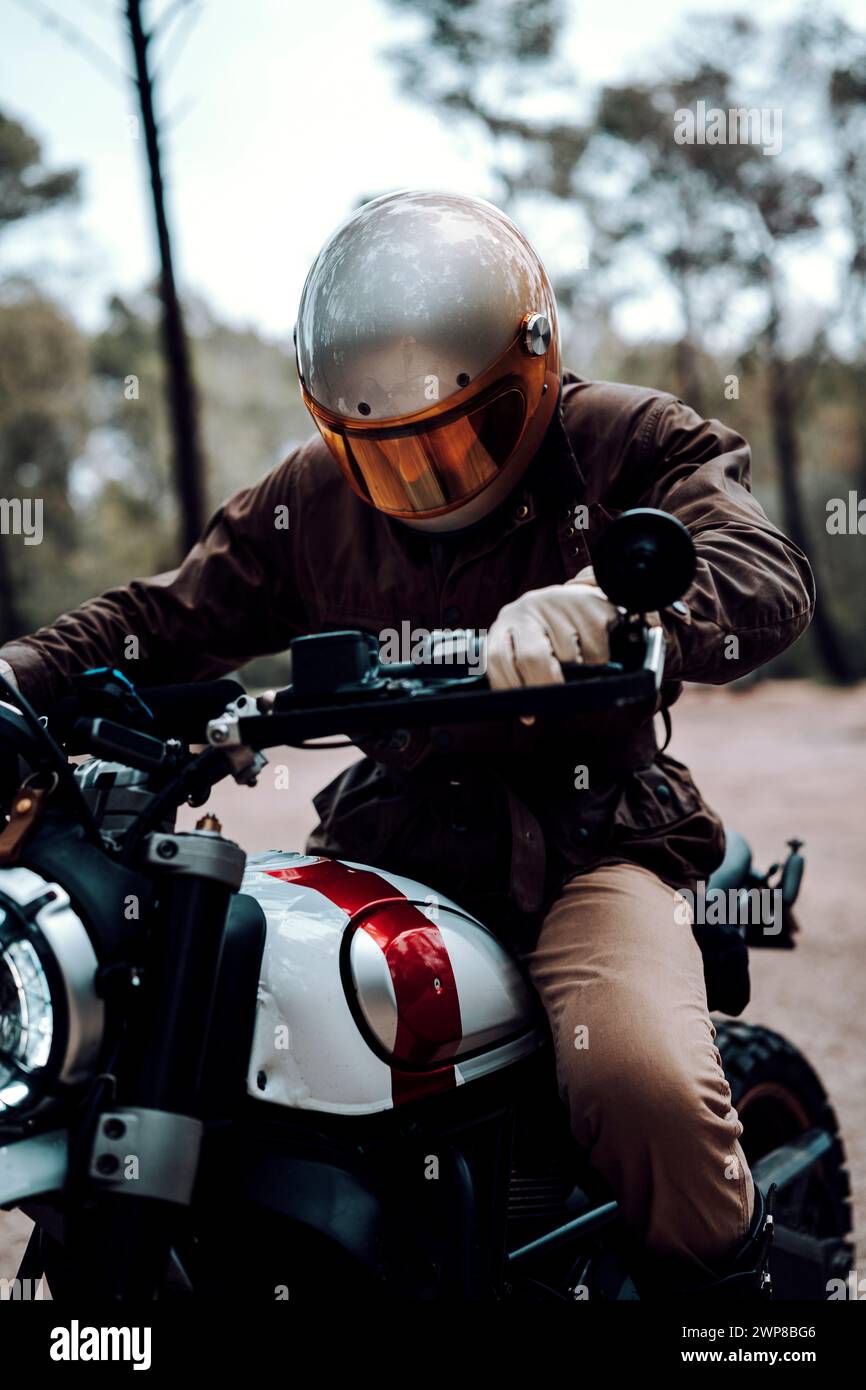 Plan vertical d'un homme assis sur une moto, saisissant le guidon Banque D'Images