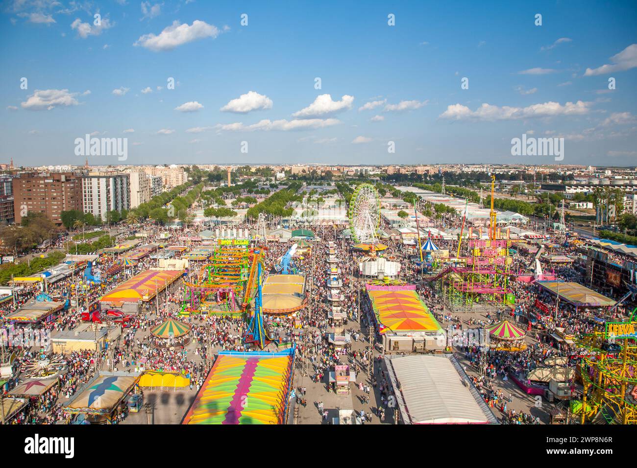 Les foules apprécient les manèges et les attractions de la foire animée d'avril de Séville. Banque D'Images