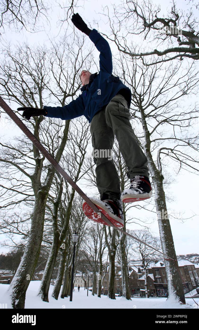 05/02/13 Wesley Southall, 17 ans, pratique la slackline à travers une ligne tendue entre les arbres à Buxton, Derbyshire lors de fortes chutes de neige. Son ami Matt Banque D'Images