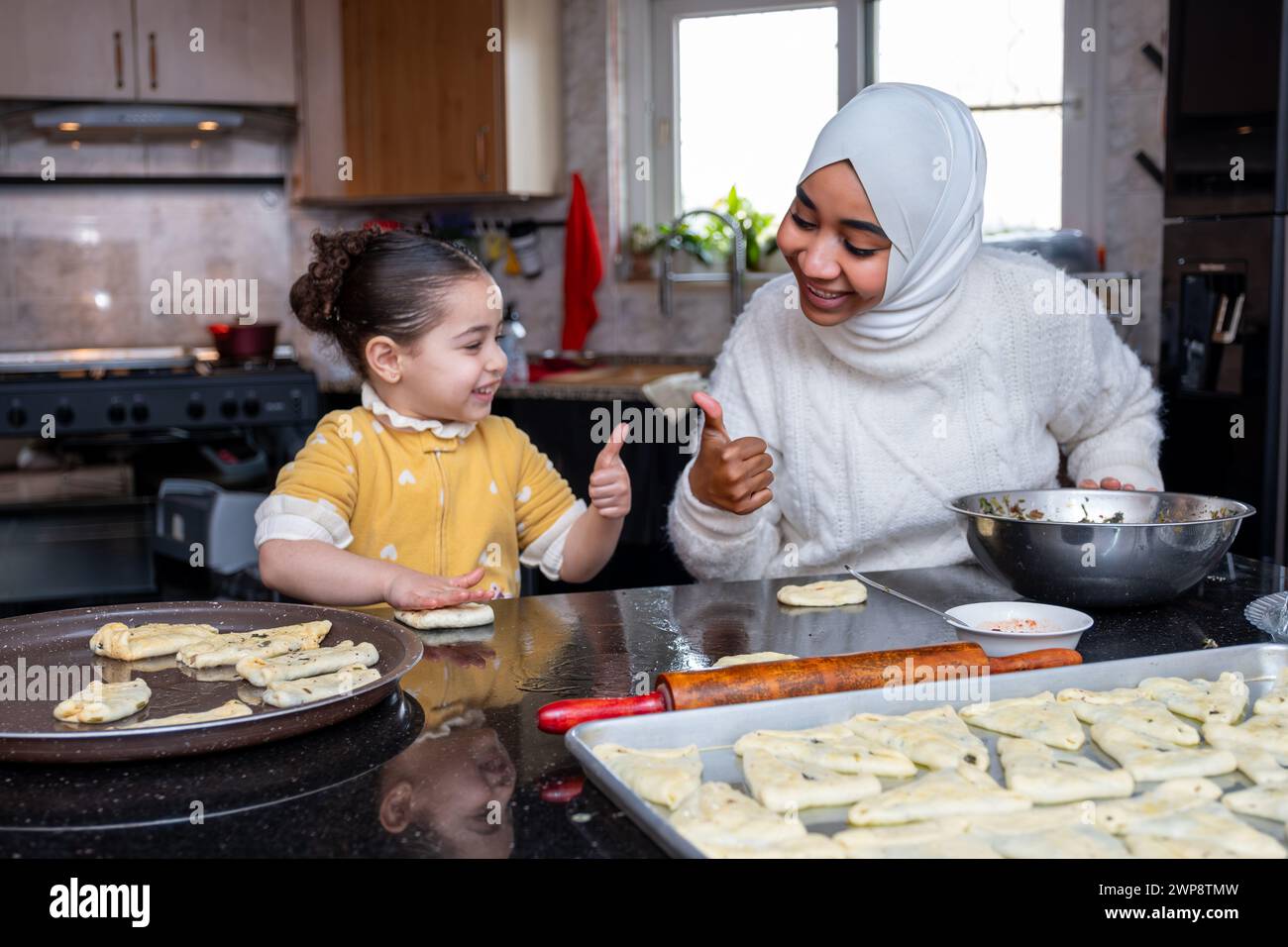 Une scène réconfortante de grand-mère et d'enfant de liaison dans la cuisine, transmettant la tradition culinaire et l'amour à travers des friandises faites maison Banque D'Images